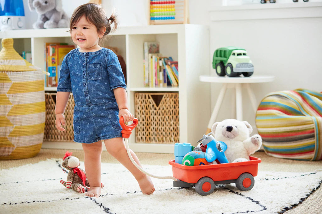 Toddler Pulling Orange Wagon Toy