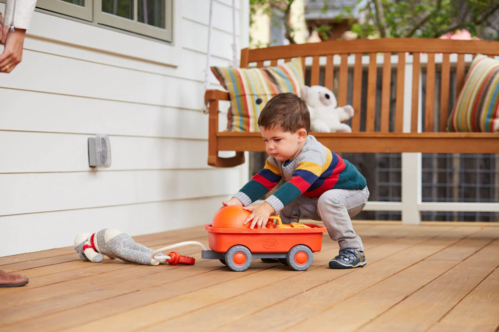 Toddler Playing with the Orange Wagon Toy